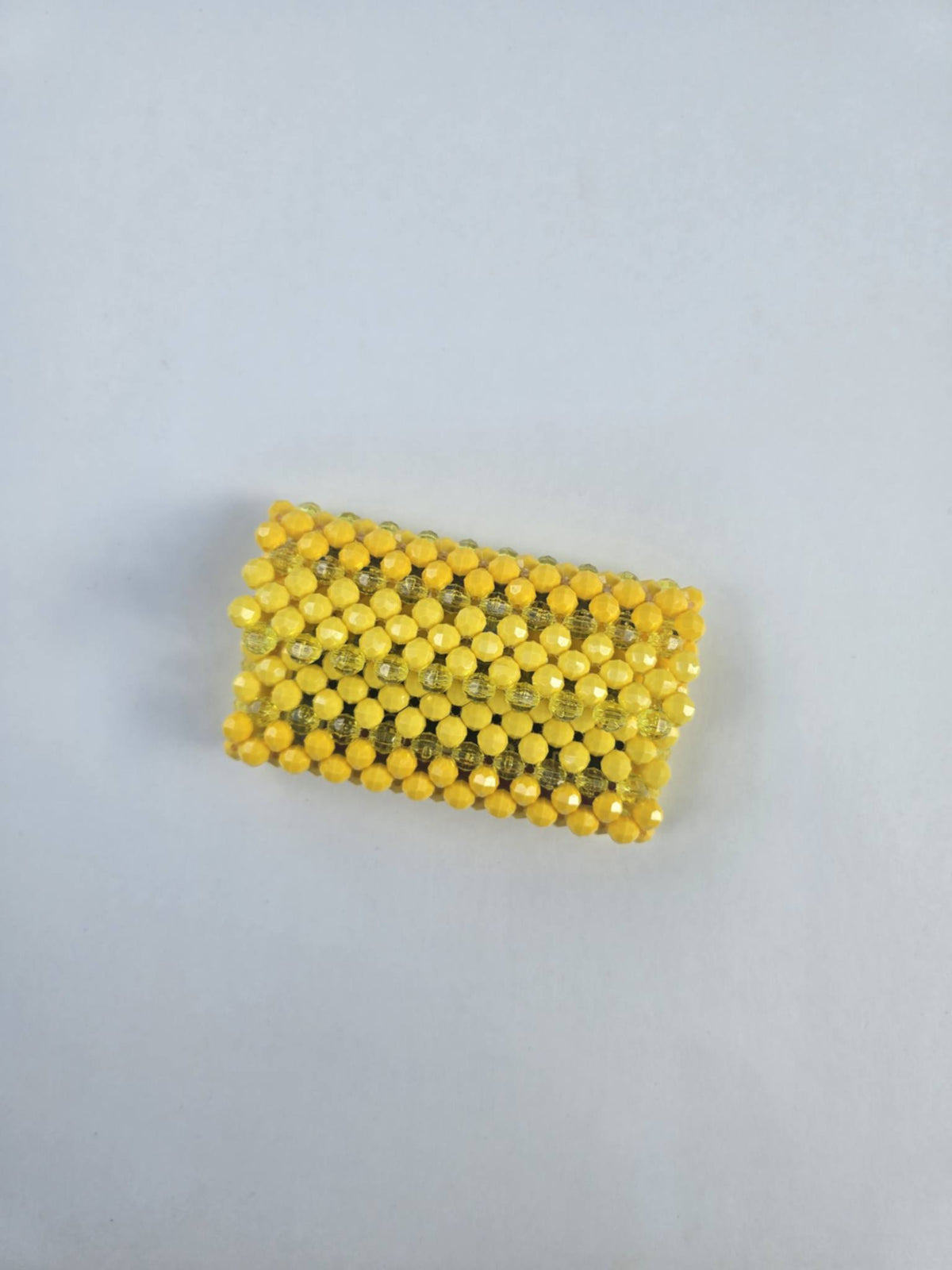 A small rectangular wallet handmade with yellow 8mm acrylic beads, photographed on a plain light gray background.